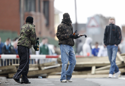 Masked youths prepare to throw molotov cocktails as they block the railway line near the house of former Irish Republican Army (IRA). Click image to expand.