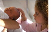 Photograph of girl and her new sister by © copyright 1999-2008 Getty Images, Inc.