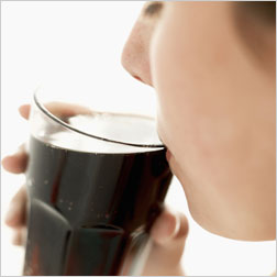 Girl sipping a glass of soda.
