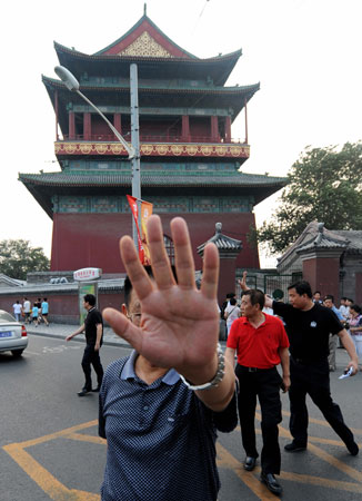 A Chinese police detective tries to block the taking of a photograph at the Drum Tower.