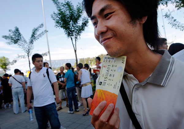 A man tries to sell a ticket to an Olympic event.