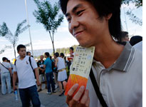 A Chinese man holds a ticket for sale outside the Olympic green. Click image to expand.