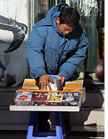 A street vendor in China selling pirated discs
Click image to expand.