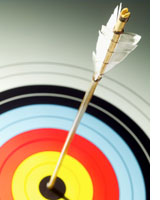 Close-up of arrow in bulls eye of target. Photograph by Stockbyte/Getty Images.