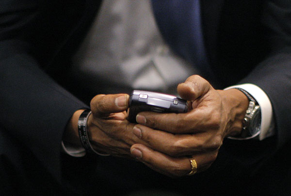 Barack Obama holds a BlackBerry.