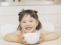Young girl with a bowl of porridge (image by Digital Vision).