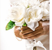 Bride with bouquet of white flowers by Jupiterimages.