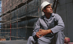 Man sitting at a construction site. Click image to expand.
