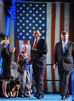 US President Barack Obama walks on to the stage with Veterans of Foreign Wars. Click image to expand.