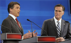 Republican presidential candidates, Texas Gov. Rick Perry (L) speaks as former Massachusetts Gov. Mitt Romney listens in the Fox News/Google GOP Debate. Click image to expand.