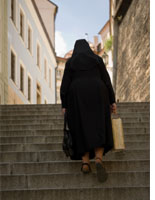 Nun climbing stairs in Prague